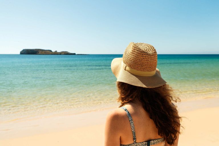 Woman on a beach looking out at the ocean