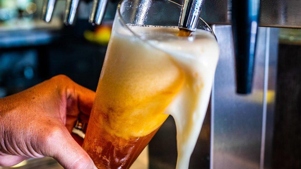 Beer pours from a tap into a tall glass at Shark Louge in the Encore Resort at Reunion Clubhouse.