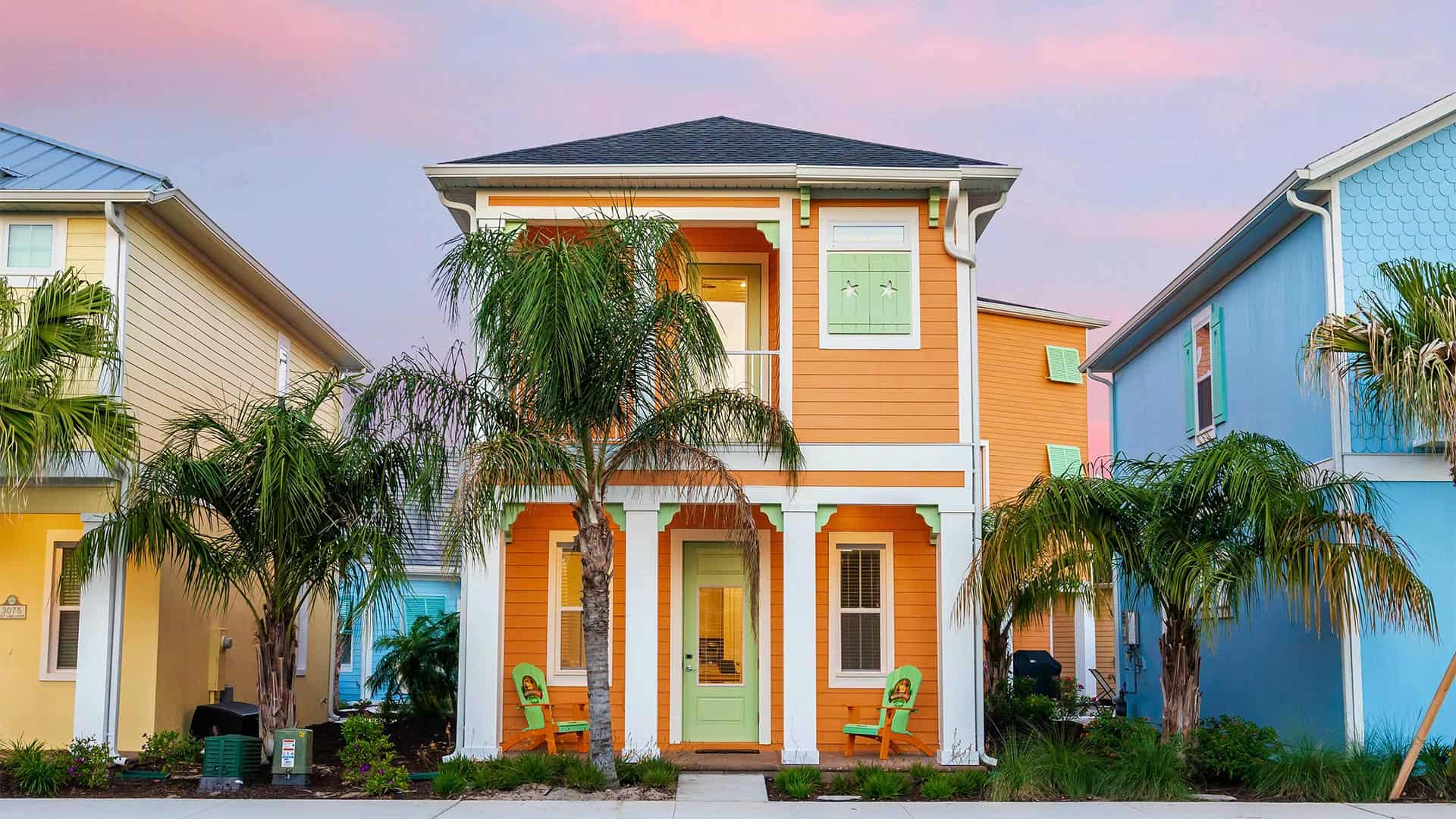 Colorful 2-story cottage with front porch and palm trees at Margaritaville Resort Orlando